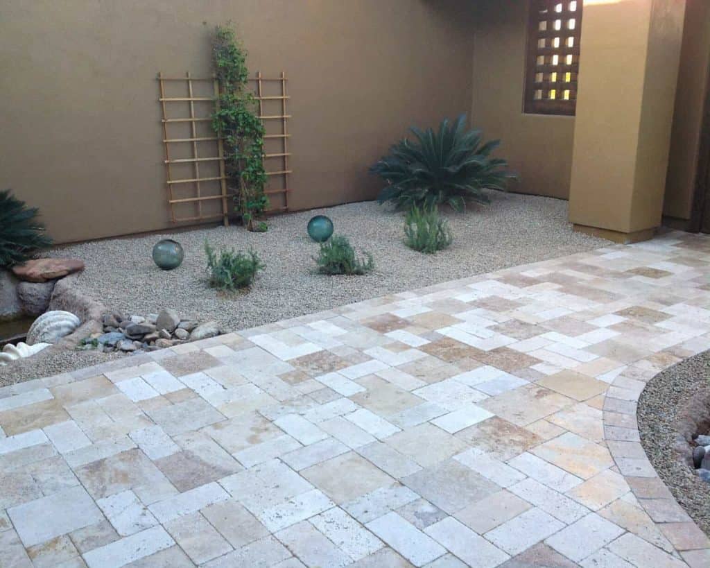 Travertine walkway with stone pavers, rock and plants and shrubs