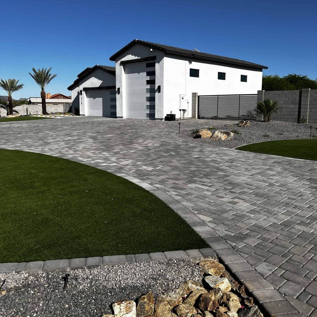 Beautiful custom stone driveway with rock and grass yard