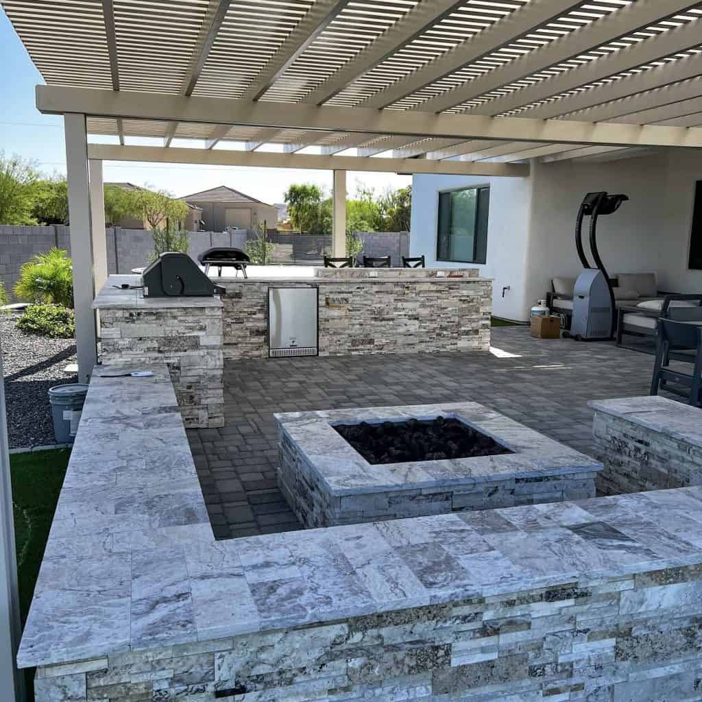Backyard full-kitchen with travertine stone fireplace, seats and more